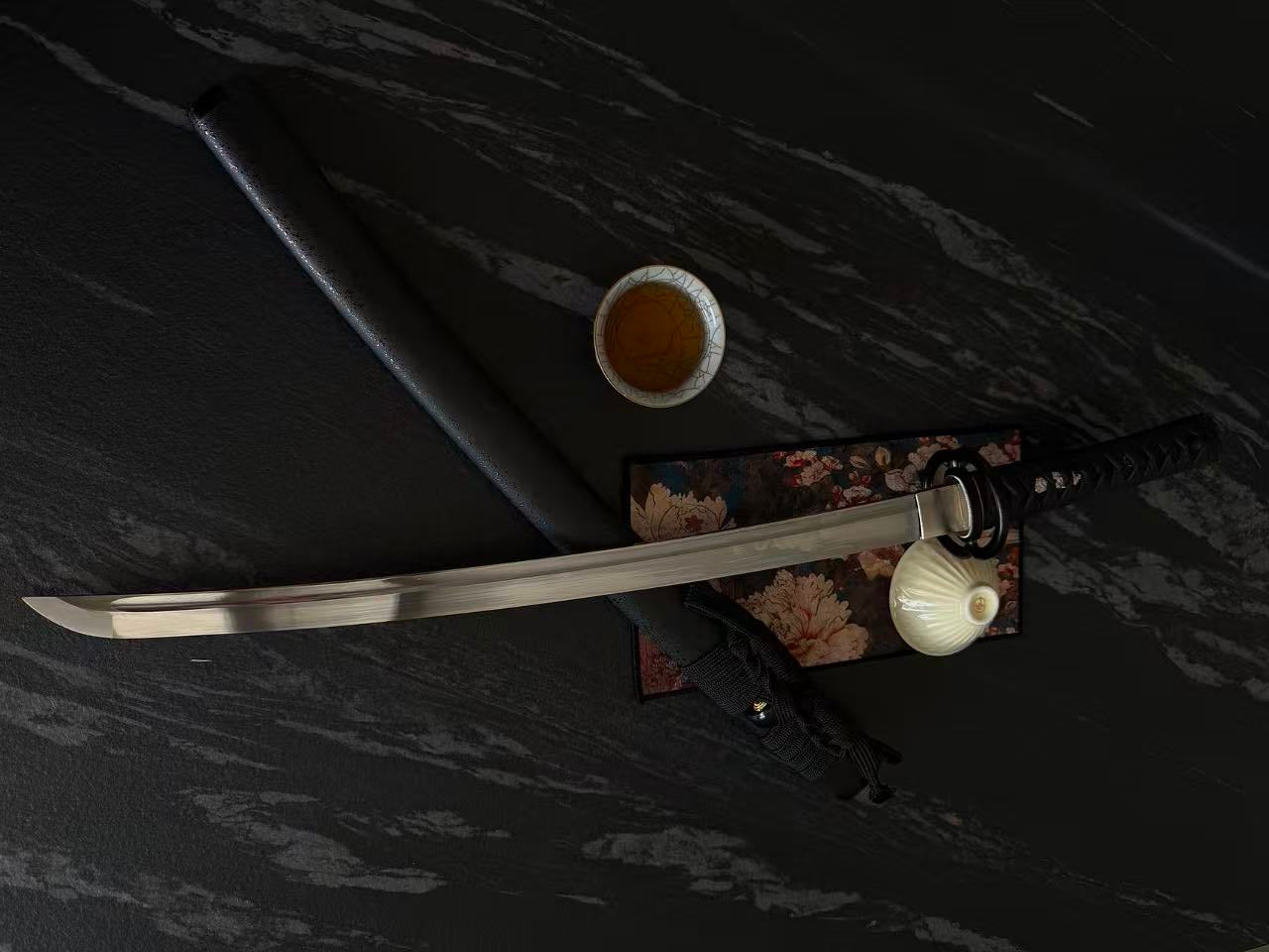 Sword with sheath on a dark marble surface